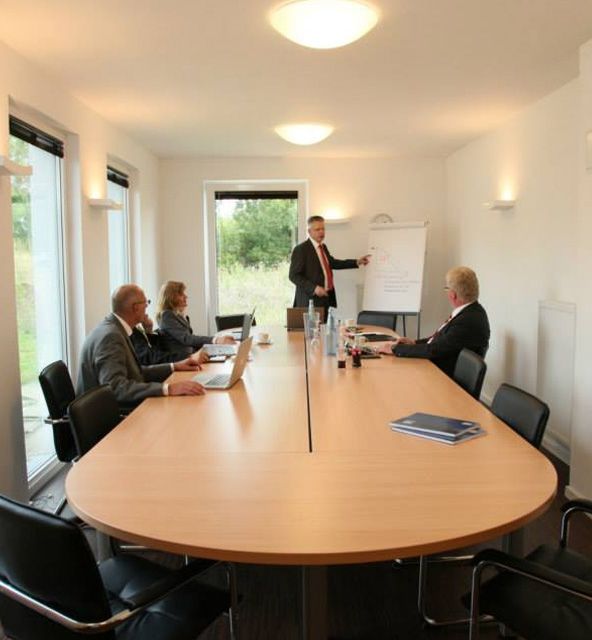 A conference room featuring a large table surrounded by several chairs, designed for meetings and discussions.